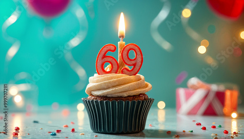 Birthday cupcake with burning lit candle with number 69. Number sixty-nine for sixty-nine years or sixty-ninth anniversary. photo