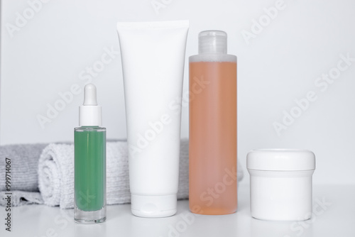 Refreshing skincare products arranged neatly on a white background with towels for self-care routine