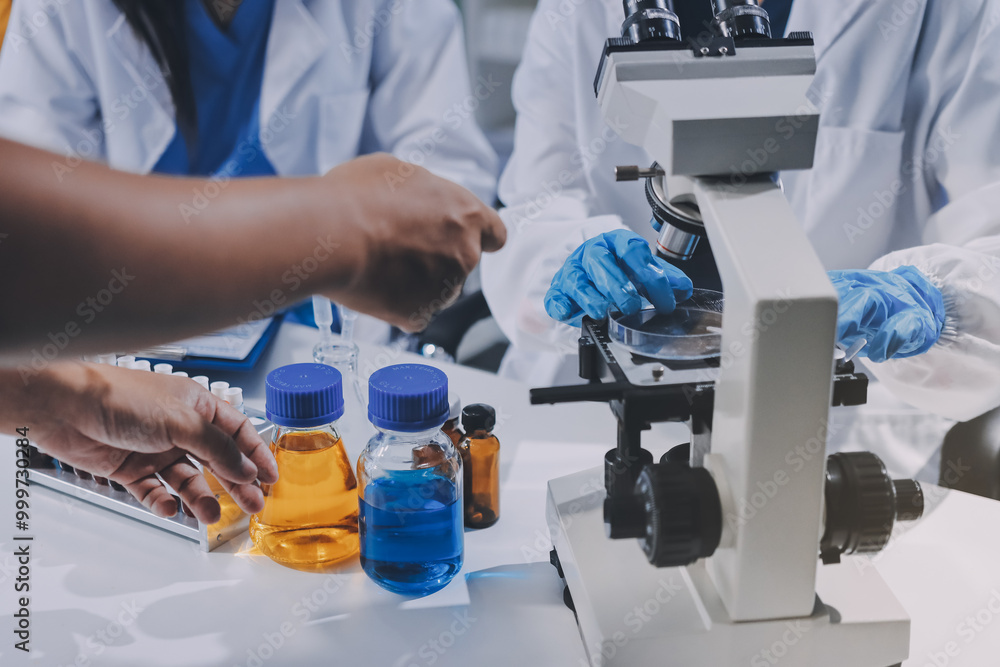 Scientist using microscope in laboratory. Close-up of a researcher's hands adjusting a modern microscope in a lab setting. Science concept Scientist using microscope in laboratory. Close-up of a researcher's hands adjusting a modern microscope in a lab setting. Science concept