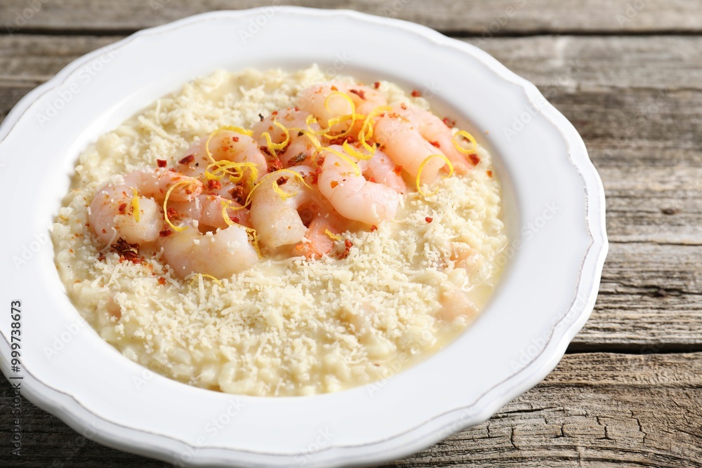 Delicious risotto with shrimps and cheese on wooden table, closeup Delicious risotto with shrimps and cheese on wooden table, closeup