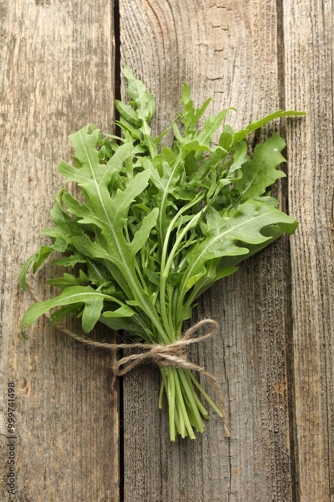 Bunch of fresh green arugula leaves on wooden table, top view Bunch of fresh green arugula leaves on wooden table, top view