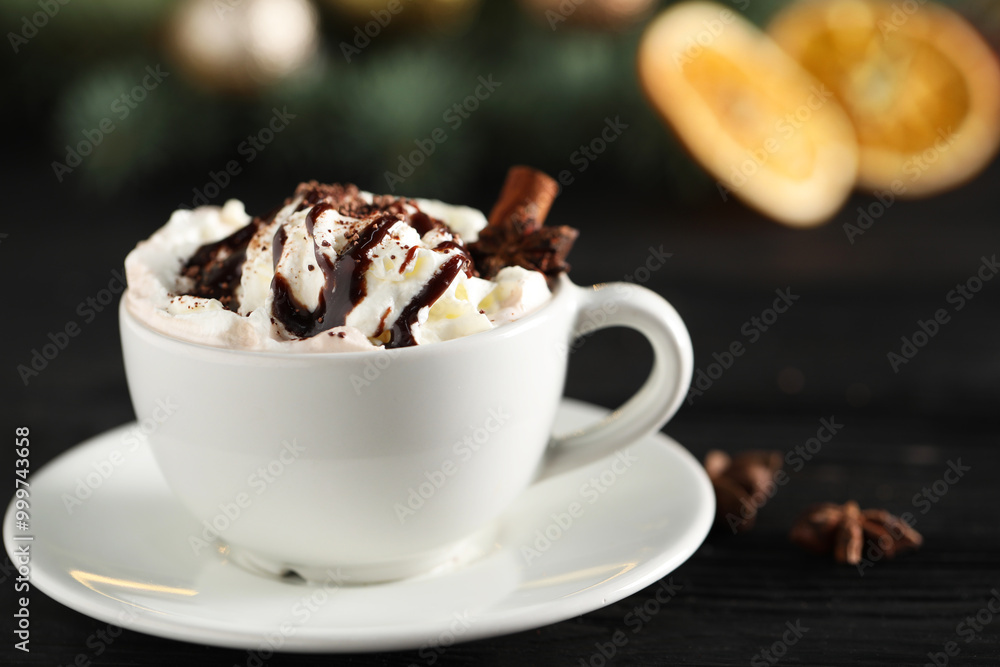 Tasty hot cocoa drink with whipped cream in cup and spices on black table, closeup Tasty hot cocoa drink with whipped cream in cup and spices on black table, closeup