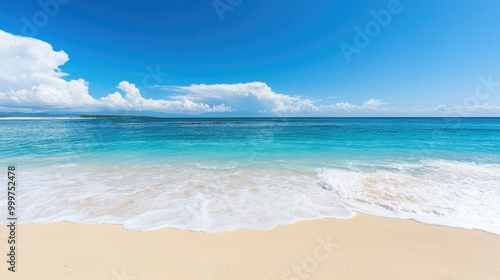 A serene beach scene with clear blue water and gentle waves lapping at the sandy shore.