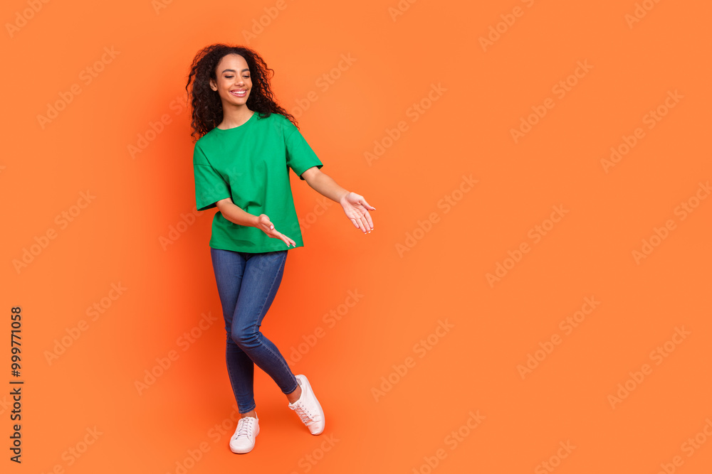 Photo of young positive girl wearing casual outfit demonstrate empty space ecommerce app isolated on orange color background Photo of young positive girl wearing casual outfit demonstrate empty space ecommerce app isolated on orange color background