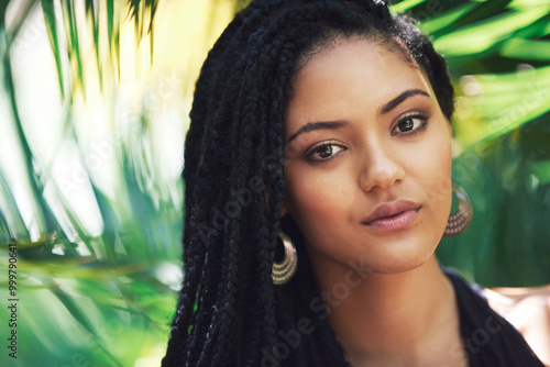 Woman, portrait and dreadlocks for haircare outdoor with organic shampoo, natural styling and frizz control. Girl, braids and beauty with strong texture, growth wellness and tropical leaf background photo