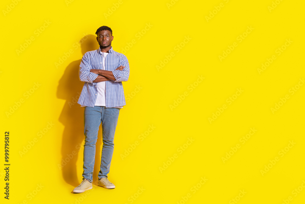 Fototapeta premium Full length photo of cheerful positive guy dressed checkered shirt hands crossed emtpy space isolated yellow color background