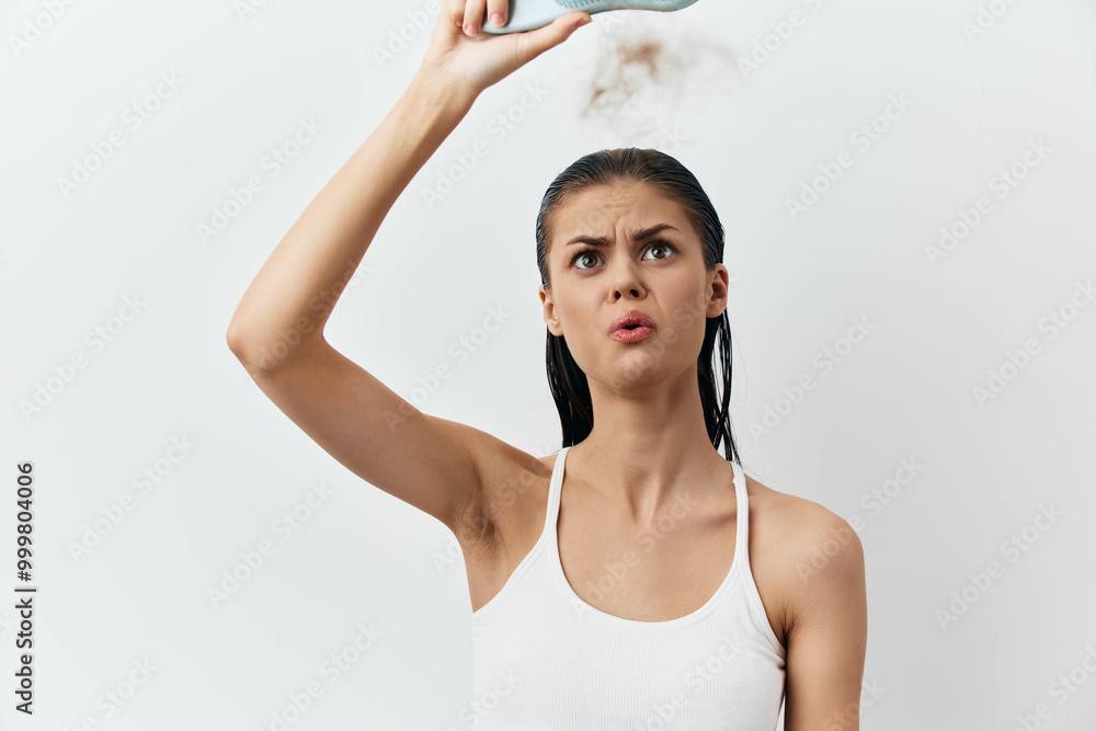 Woman looking confused while holding a hair straightener, steam rising from it The image depicts a young woman with wet hair in a white tank top against a plain white background