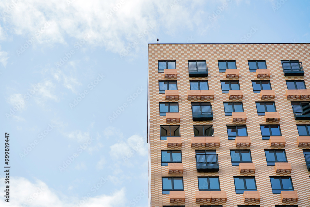 A Modern Apartment Building With Balconies Under a Clear Blue Sky During Daylight Hours in an Urban Setting A Modern Apartment Building With Balconies Under a Clear Blue Sky During Daylight Hours in an Urban Setting