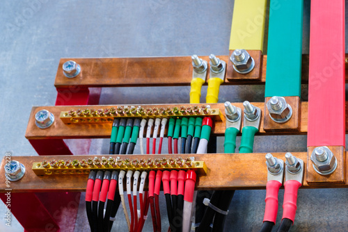 Photos Many power electric wires multi-colored wires and nuts connected to copper metal busbars electric three phases of high industrial voltage
