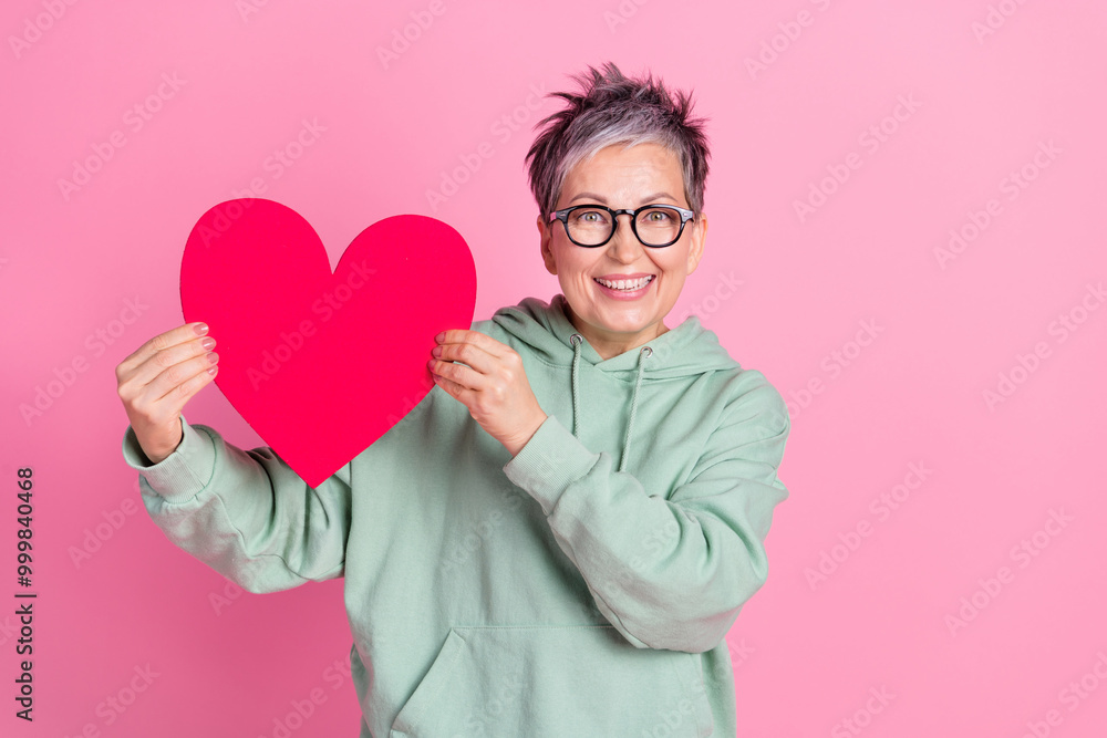 Photo of charming attractive lady wear khaki hoodie holding big red heart isolated pink color background Photo of charming attractive lady wear khaki hoodie holding big red heart isolated pink color background