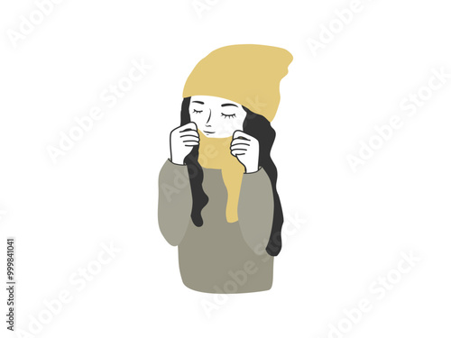 ニット帽をかぶりマフラーをして寒そうにする女性