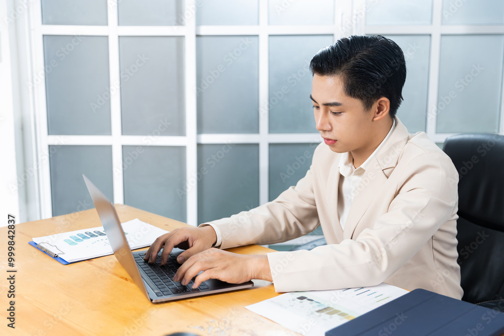 Asian businessman working in his office reviewing work, accessing planning strategy, creative thinking and innovation ideas, sitting at his desk using laptop computer, professional business worker. Asian businessman working in his office reviewing work, accessing planning strategy, creative thinking and innovation ideas, sitting at his desk using laptop computer, professional business worker.
