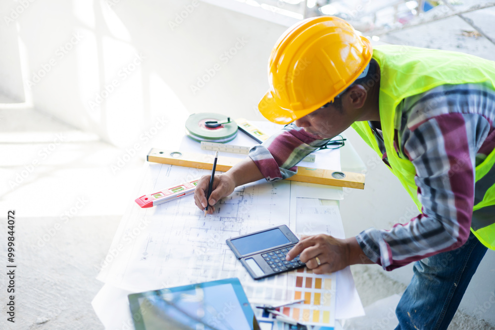 Asian architecture designing blueprint planning using pencil ruler measuring drawing, working in construction site, engineer worker building innovation, wearing safety vest and helmet gears. Asian architecture designing blueprint planning using pencil ruler measuring drawing, working in construction site, engineer worker building innovation, wearing safety vest and helmet gears.