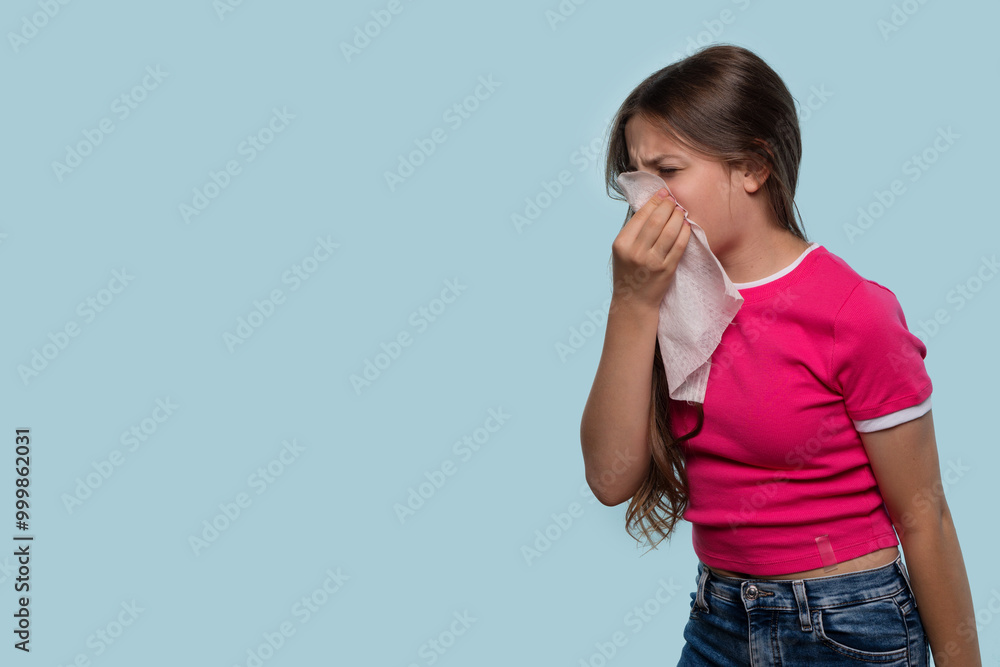 Girl sneezes into tissue, wearing pink shirt. Girl sneezes into tissue, wearing pink shirt.