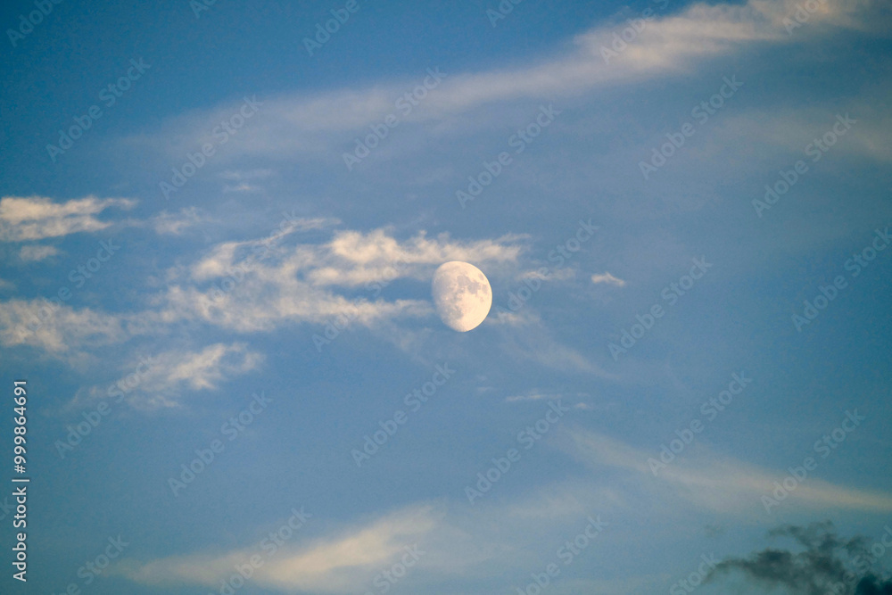 close up view of the moon during the day,full moon view of the moon on a blue and cloudy day close up view of the moon during the day,full moon view of the moon on a blue and cloudy day
