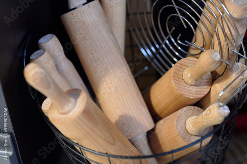 Obraz na płótnie Collection of Wooden Rolling Pins in a Metal Basket, Indoors, Captured in Soft Ambient Lighting w salonie