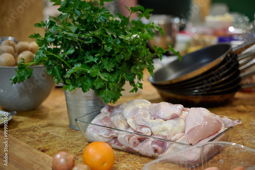Prepping for a Fresh Home-Cooked Meal: Raw Chicken, Vegetables, and Herbs Set in a Warm Kitchen Ambience
