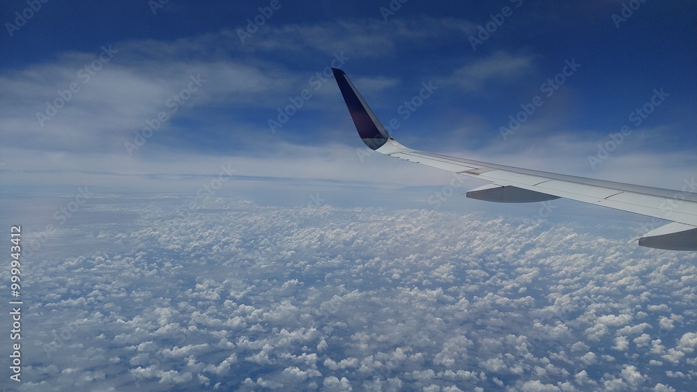 Fototapeta premium view of clouds with blue sky from behind the plane window