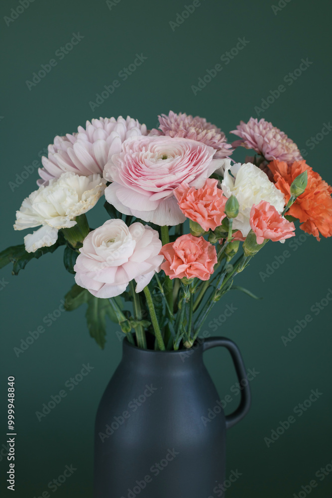 Close-up of a bunch of pink and orange carnation and ranunculus flowers in a ceramic vase Close-up of a bunch of pink and orange carnation and ranunculus flowers in a ceramic vase
