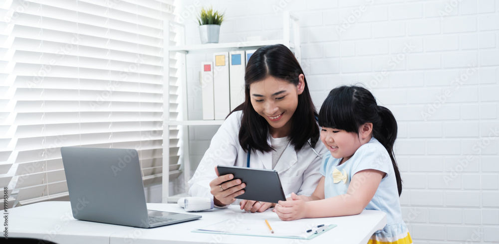 Asian doctor diagnosing on young girl patient using digital tablet ...