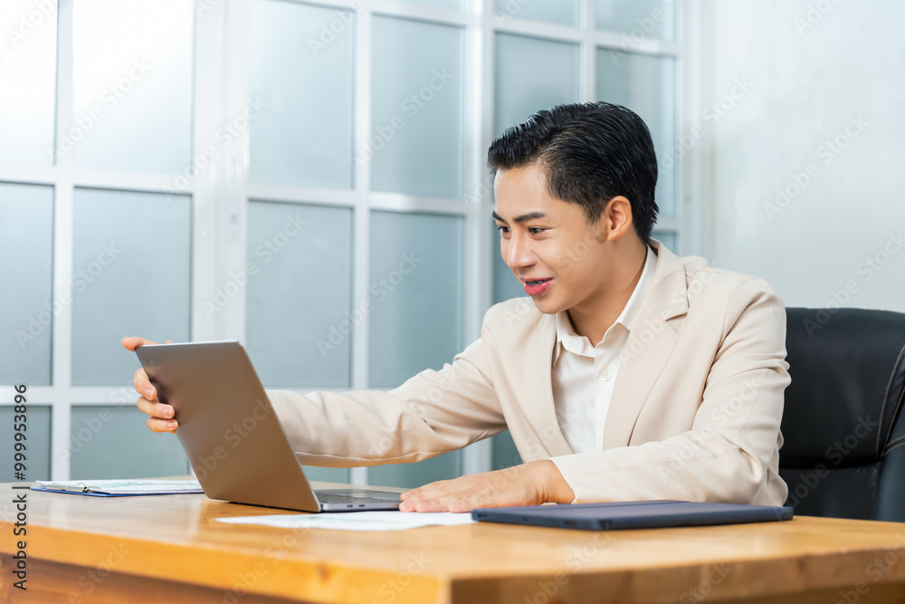 Asian businessman working in his office reviewing work, accessing planning strategy, creative thinking and innovation ideas, sitting at his desk using laptop computer, professional business worker. Asian businessman working in his office reviewing work, accessing planning strategy, creative thinking and innovation ideas, sitting at his desk using laptop computer, professional business worker.