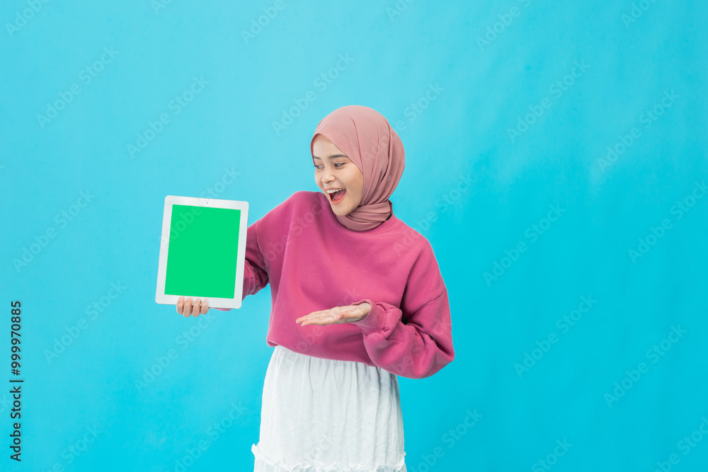 A joyful woman in a pink sweater showcases a green frame against a vibrant blue backdrop. A joyful woman in a pink sweater showcases a green frame against a vibrant blue backdrop.