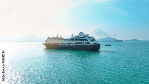 Cruise ship sailing in the ocean aerial view from above. Aerial for the passenger liner with many people on board relaxing under the bright sun.