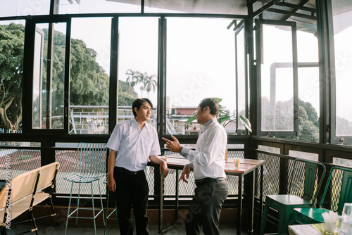 Two Southeast Asian men engaging in an enthusiastic conversation