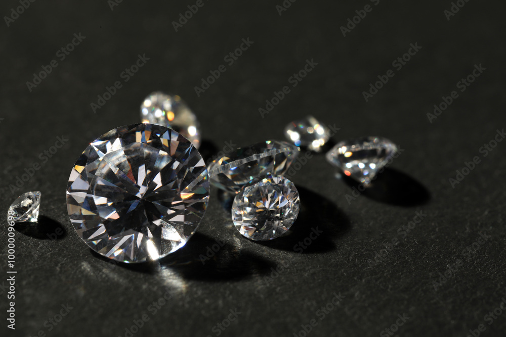 Many beautiful shiny diamonds on grey table, closeup Many beautiful shiny diamonds on grey table, closeup