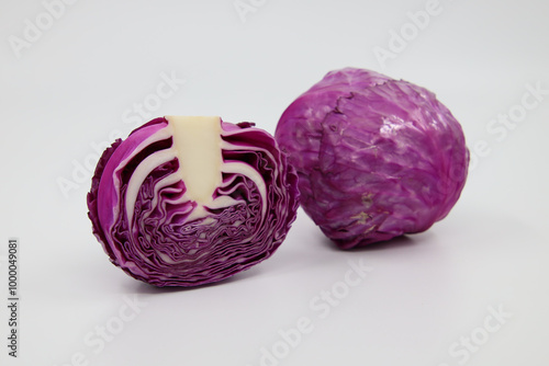 Sliced and whole purple cabbage on a white background, showcasing vibrant layers and textures photo