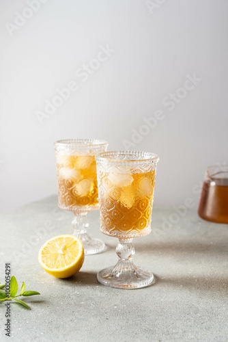 Black tea with ice and lemon in a tall glass. Cold lemonade. 