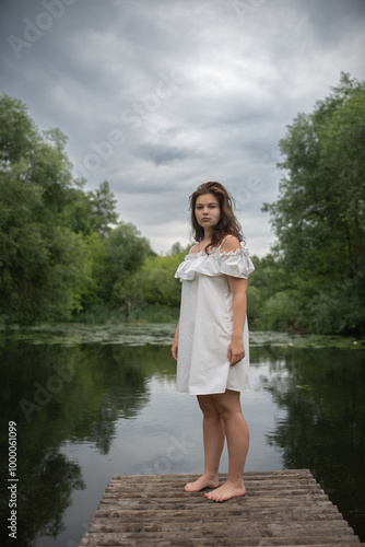 Beautiful young dark-haired girl by the river.