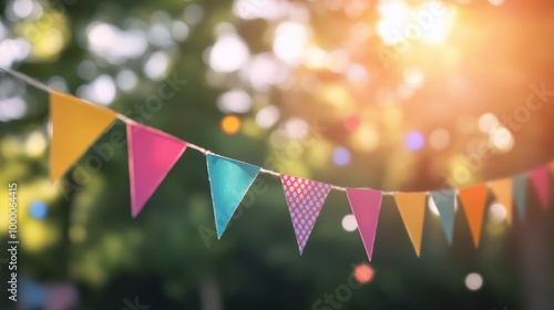 Colorful string of festival bunting decorations in a sunlit outdoor setting d...