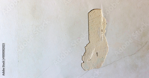 A chipped wall with peeling paint and visible texture, showing underlying plaster inminimalistic setting.
