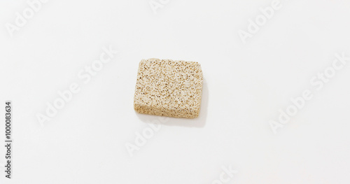 Close up of beige pumice stone on plain white background.