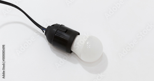 Black plastic light socket with white LED bulb attached to black cord on white background.