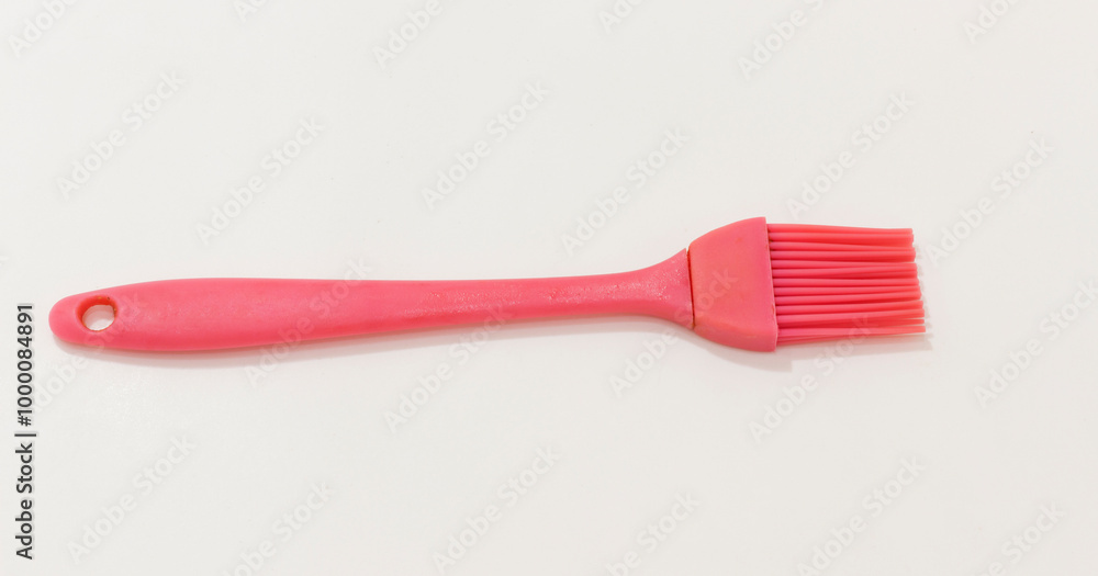 A pink silicone basting brush with hole in the handle, ideal for cooking and baking tasks. A pink silicone basting brush with hole in the handle, ideal for cooking and baking tasks.