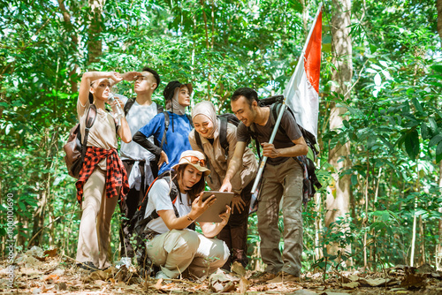 young asian traveler explore a forest and searching the route using tablet photo