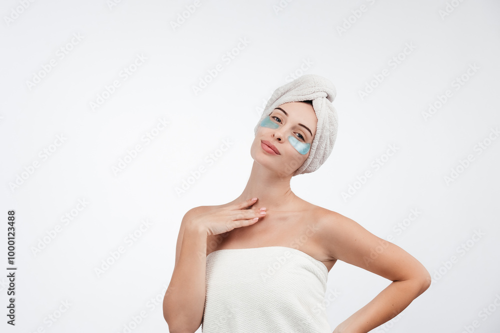 A beautiful woman with blue eyes against a white background, wearing under-eye patches and a towel on her head. Cosmetology ads concept. Healthy, glow skin. Free copy space, banner A beautiful woman with blue eyes against a white background, wearing under-eye patches and a towel on her head. Cosmetology ads concept. Healthy, glow skin. Free copy space, banner
