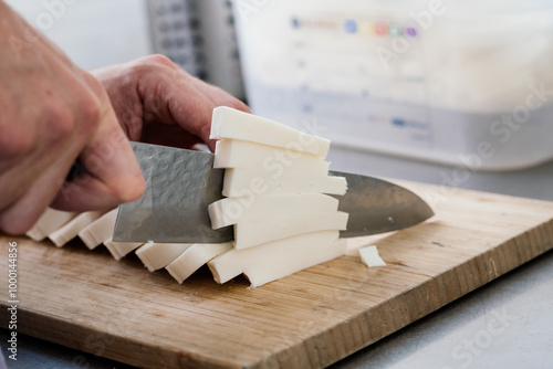 slicing mozzarella cheese on a cutting board