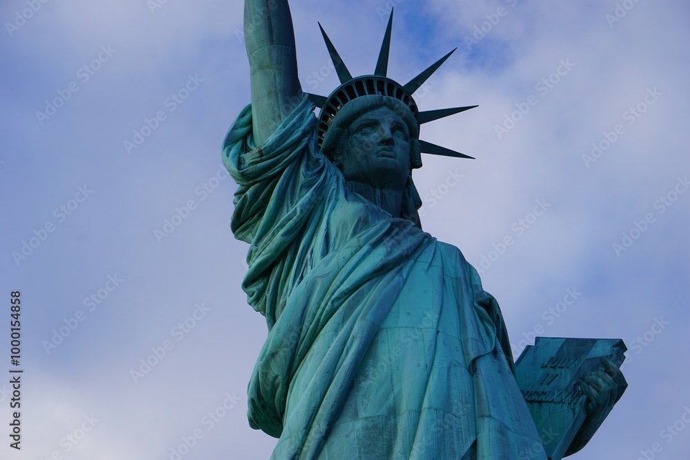 Fototapeta premium Close Up der Freiheitsstatue in New York, Symbol amerikanischer Freiheit und beliebte Tourismus Attraktion, vor wolkigem Himmel im Winter