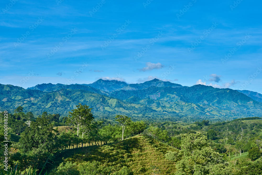 Naklejka premium green mountain range with blue sky and clouds