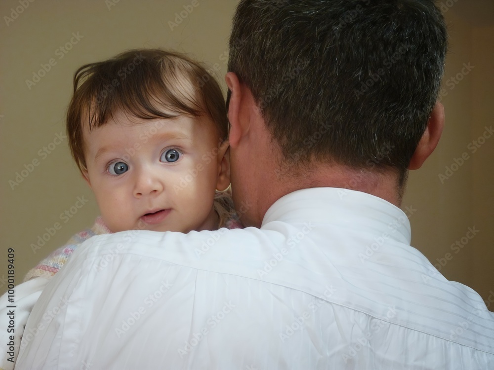 A father's protective embrace symbolizes the strength and safety of family, while the innocent gaze of the baby hints at a future filled with curiosity and wonder. Love, care, and hope wrapped in one. A father's protective embrace symbolizes the strength and safety of family, while the innocent gaze of the baby hints at a future filled with curiosity and wonder. Love, care, and hope wrapped in one.