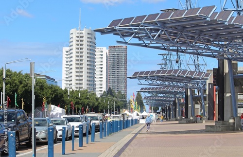 A streetscape of Olympic Blvd showing apartment buildings in the background and large-scale photovoltaic solar collection panels at Olympic Plaza  photo