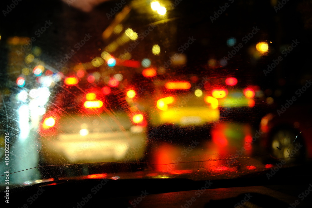 Defocused Windshield wipers from inside of car, season rain, filter color effect, night city Defocused Windshield wipers from inside of car, season rain, filter color effect, night city