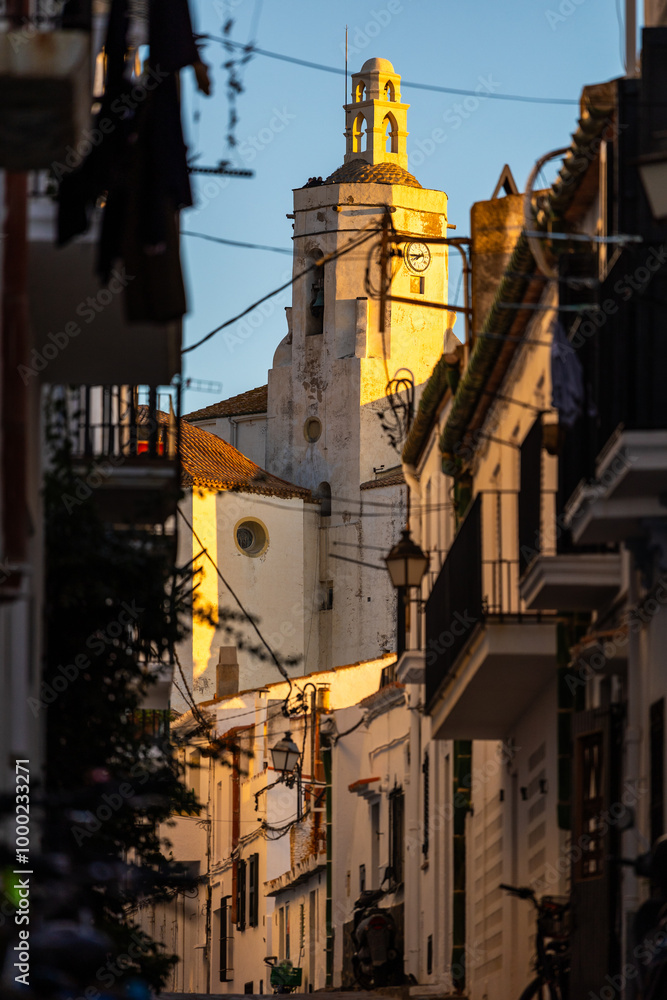Església Santa María de Cadaqués éclairée par le soleil levant depuis une ruelle Església Santa María de Cadaqués éclairée par le soleil levant depuis une ruelle