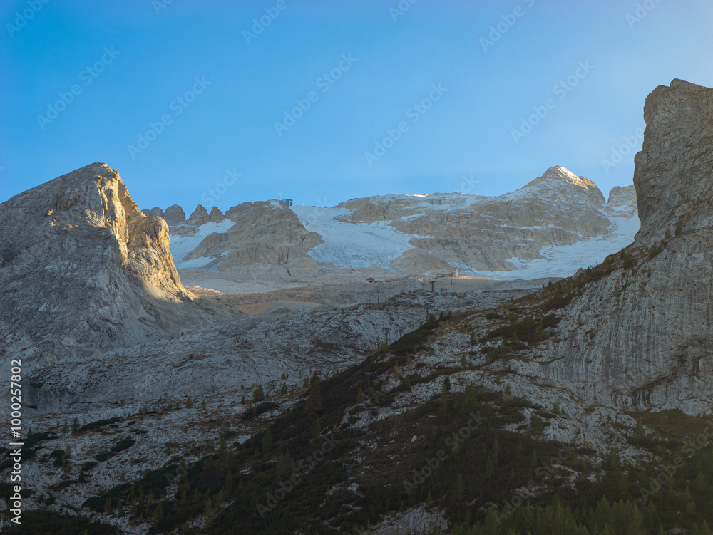 CLOSE UP: Majestic glacial peaks of Dolomites overlook the rugged terrain below. Breathtaking shot capturing the stark beauty of alpine peaks in rural Italy, highlighted by the summer morning light. CLOSE UP: Majestic glacial peaks of Dolomites overlook the rugged terrain below. Breathtaking shot capturing the stark beauty of alpine peaks in rural Italy, highlighted by the summer morning light.