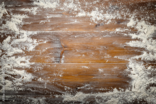 Wheat flour sprinkled on pastry board. Wooden background, top view, space for text.