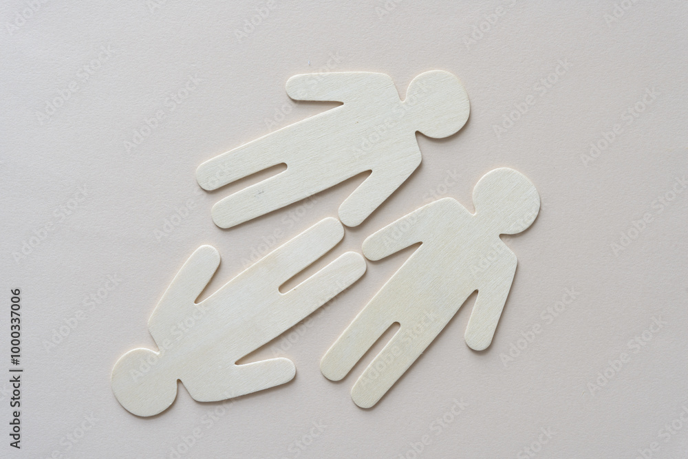 three wooden stick figures on blank paper three wooden stick figures on blank paper