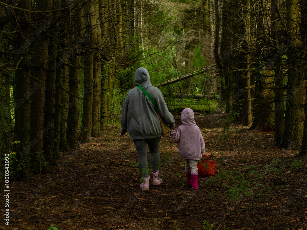 mother and daughter picking mushrooms in the forest mother and daughter picking mushrooms in the forest